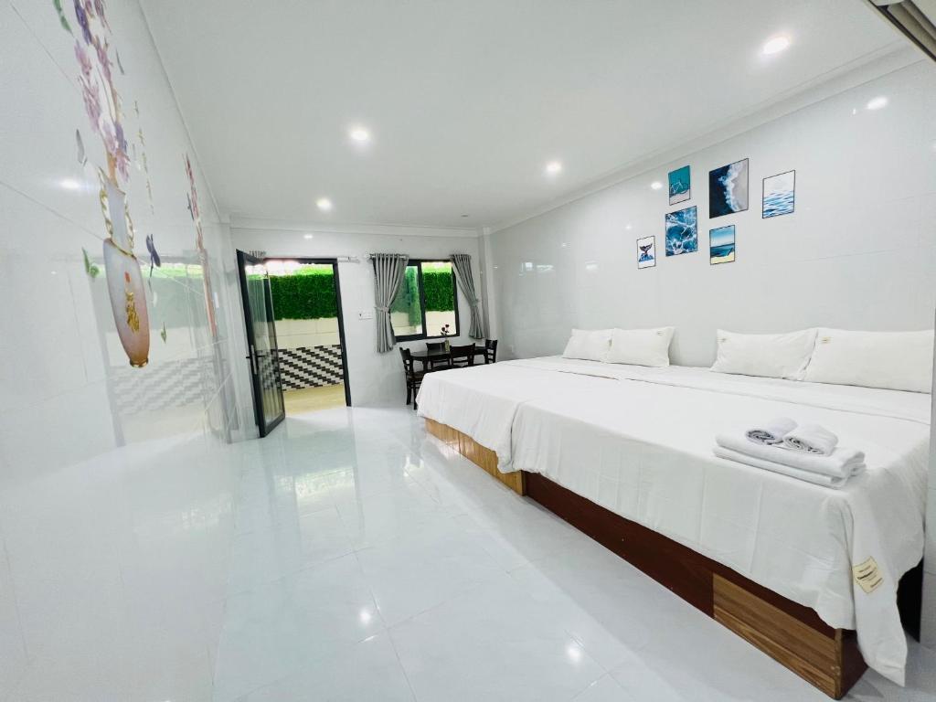a white bedroom with a large white bed in it at Homestay Dương Đông Town in Phu Quoc