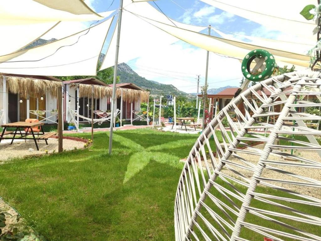 a white fence in a yard with a house at ZEYOS LODGE HOTEL&RESTAURANT in Kumluca