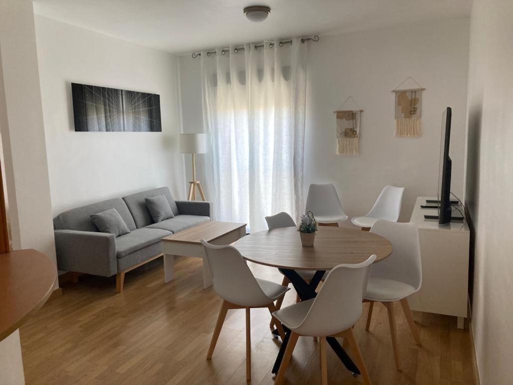 sala de estar con mesa, sillas y sofá en Apartamento Casco Antiguo, en Linares