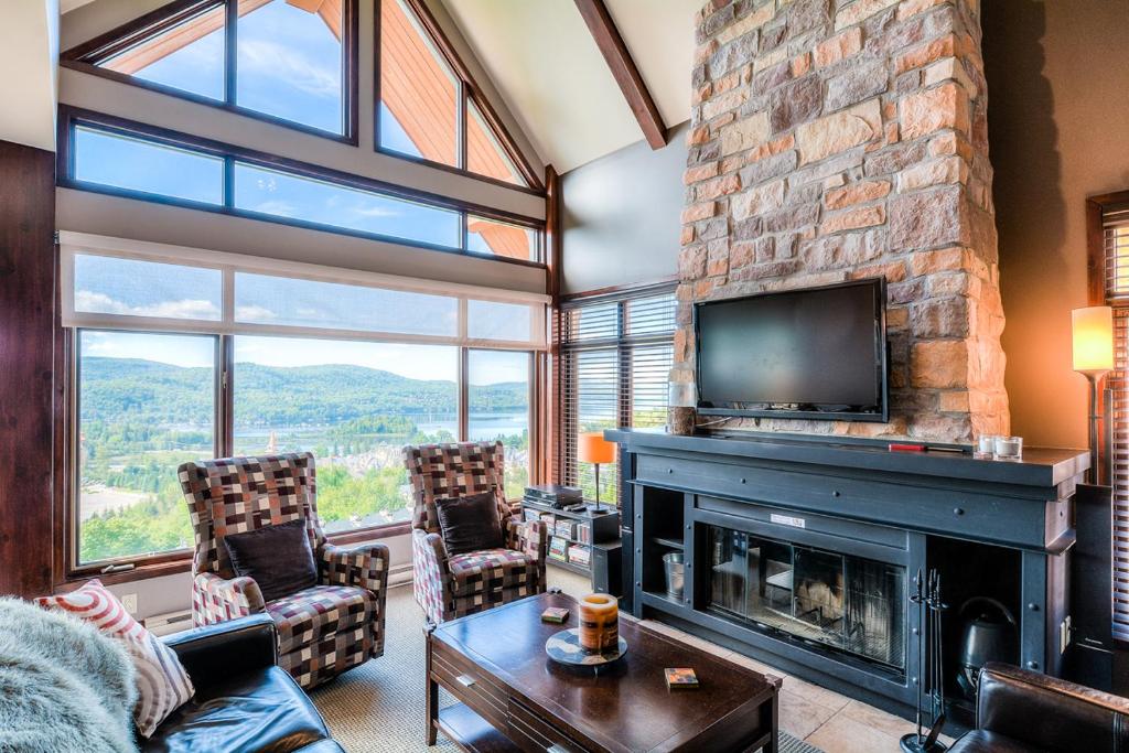 sala de estar con chimenea y TV en Luxurious Altitude Ski-in/Ski-out en Mont-Tremblant