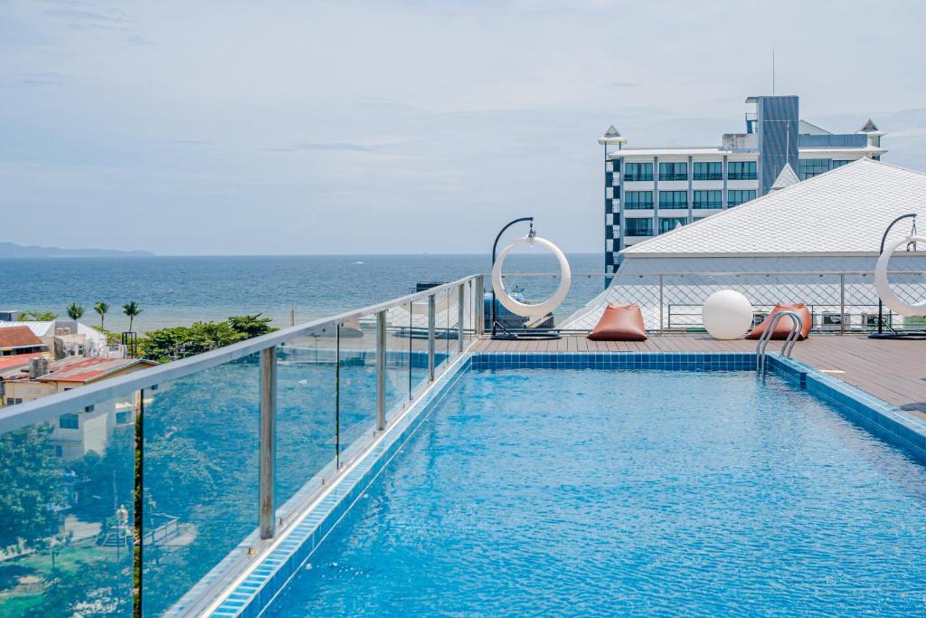 a swimming pool on top of a building with the ocean at HT9 Hotel in Jomtien Beach