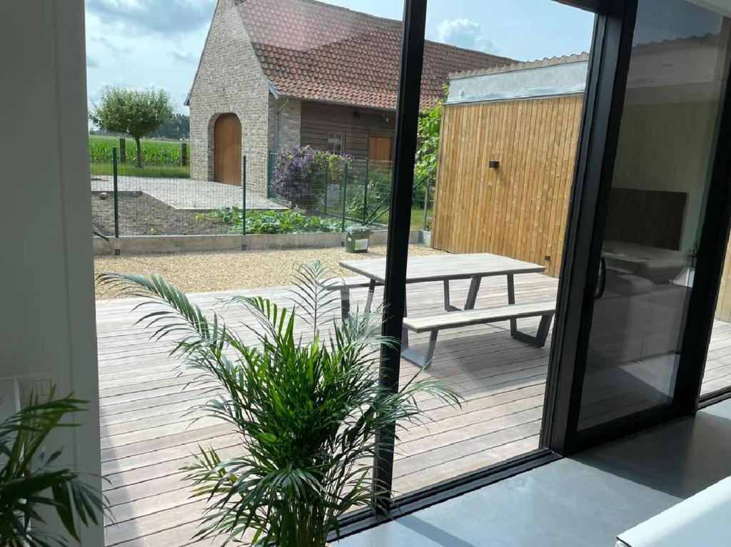 een houten terras met een picknicktafel en een bank bij Maison Beau in Veurne