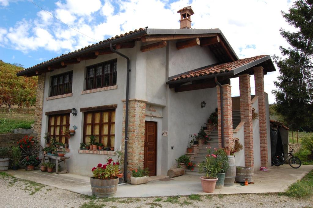 a small white house with a porch and stairs at Agriturismo 'd Rainè in Montelupo Albese