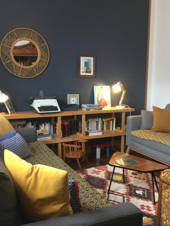 a living room with a couch and a table at La Ptite Fabrique chez Malot in Montceau-les-Mines