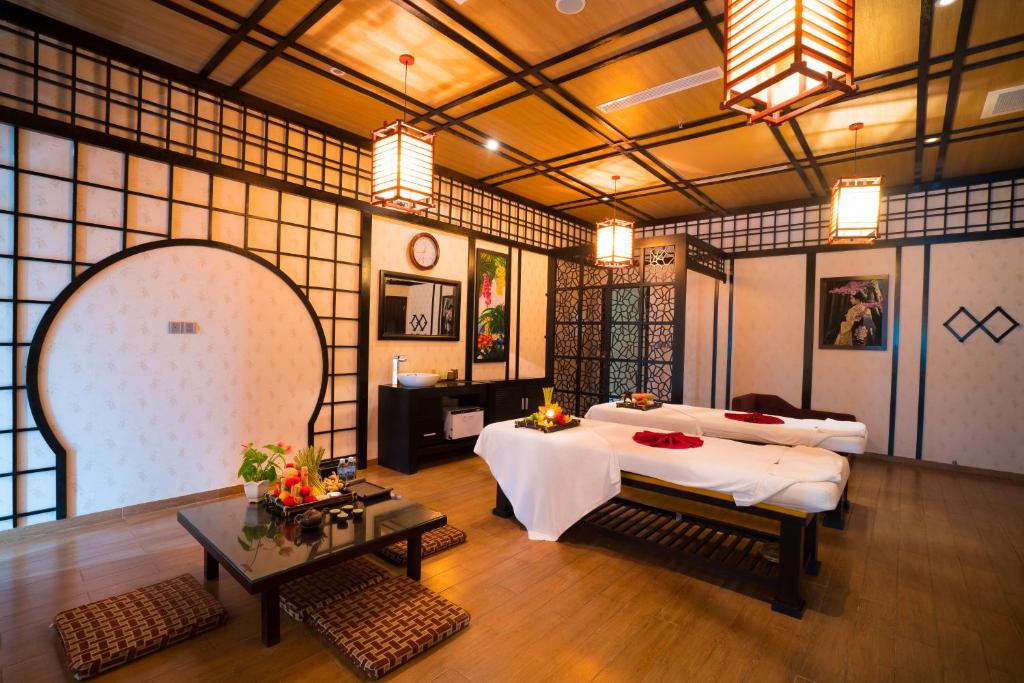 a large room with two beds and a table at Galina Hotel & Spa in Nha Trang