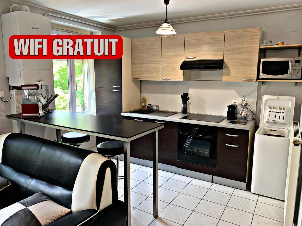 アンネヴィルにあるPôle Thermal & Touristique Amnévilleのキッチン(黒いテーブル、白い冷蔵庫付)