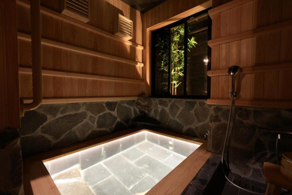 uma banheira num quarto com uma janela em お宿 櫻川　Oyado Sakuragawa em Fujiyoshida