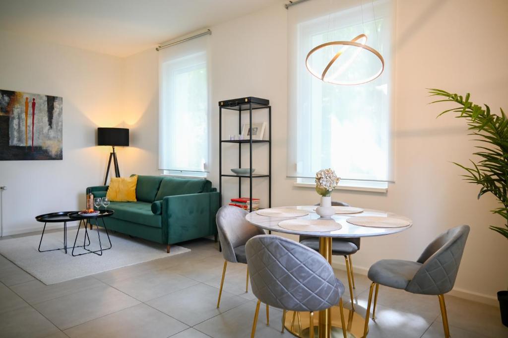 ein Wohnzimmer mit einem Tisch und einem grünen Sofa in der Unterkunft Modernes Apartment in Berlin in Berlin