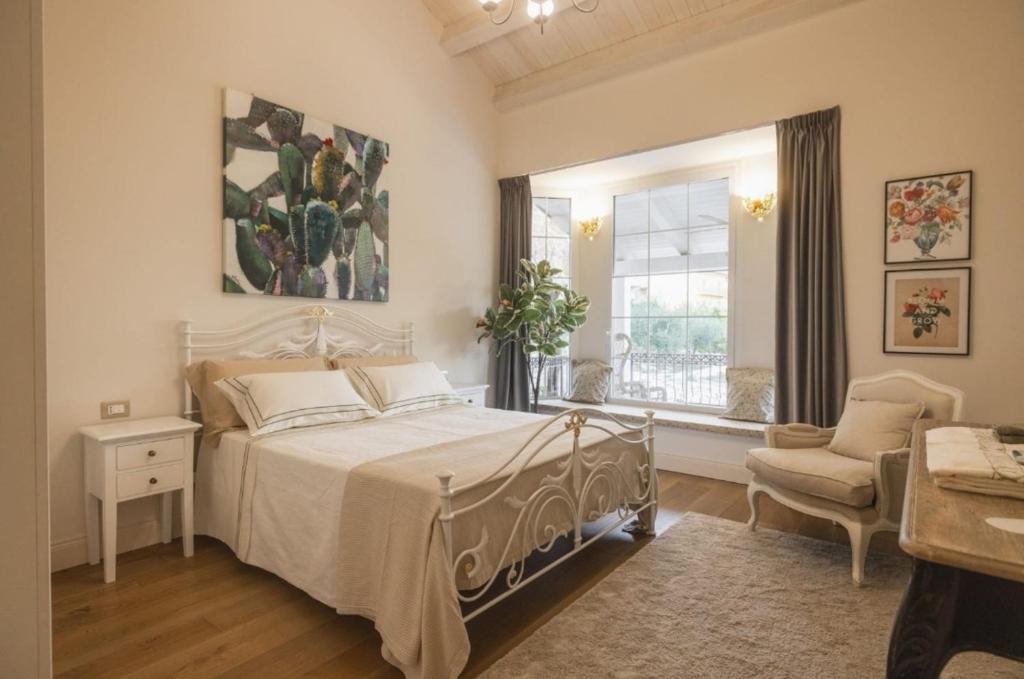 a bedroom with a bed and a window and a chair at Villa Platani Luxury Suite in Cianciana