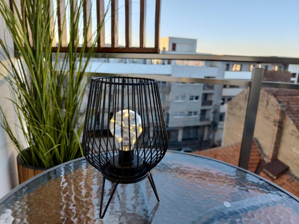 a candle in a cage sitting on a glass table at SWEET HOME - central cozy apartment in Cluj-Napoca