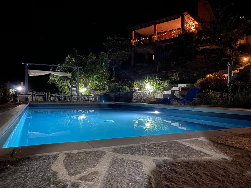 - une piscine la nuit avec une maison en arrière-plan dans l'établissement Farm Stay Herbarium Citra 011026-LT-0076, à Santo Stefano di Magra