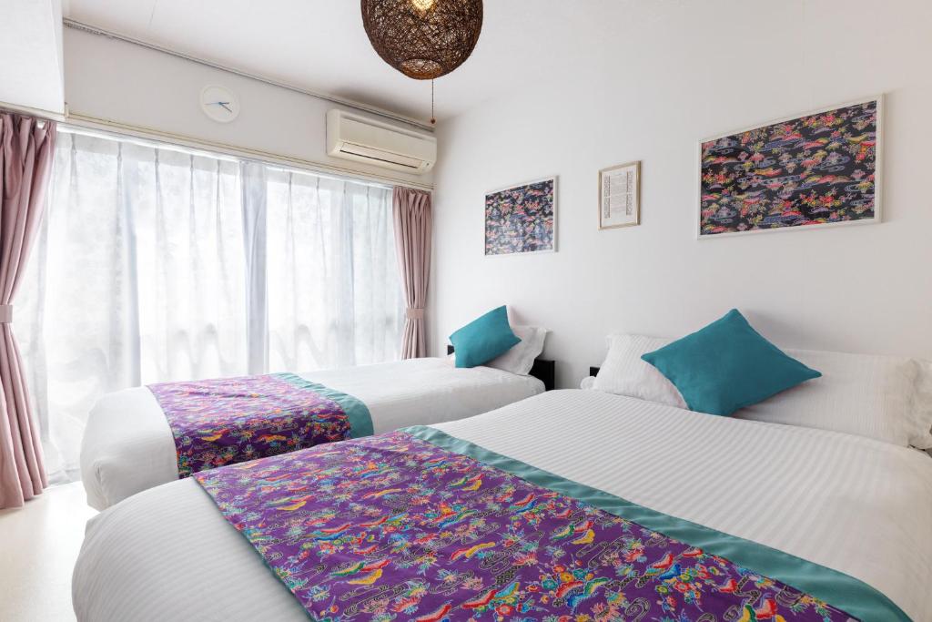 a hotel room with two beds and a window at ハレアカラ - 4階建てプライベートマンション in Asato