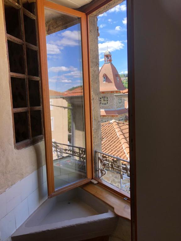 an open window with a view of a balcony at Mademoiselle Canonge in Lamastre