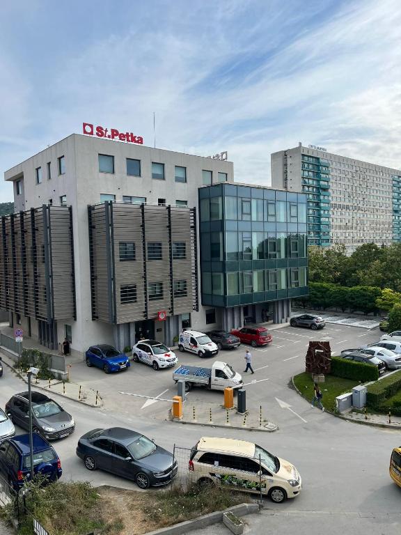 a parking lot with cars parked in front of a building at Apartment Sanik in Varna City