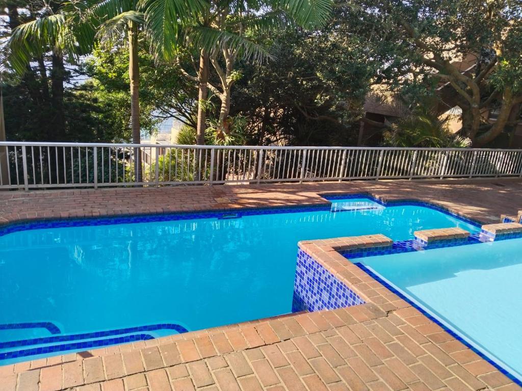 a blue swimming pool with a fence around it at 21 Camarque in Umdloti
