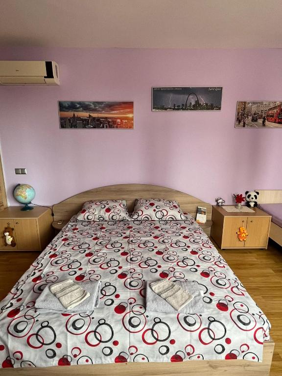 a bedroom with a large bed with red and white blankets at Apartment Sanik in Varna City