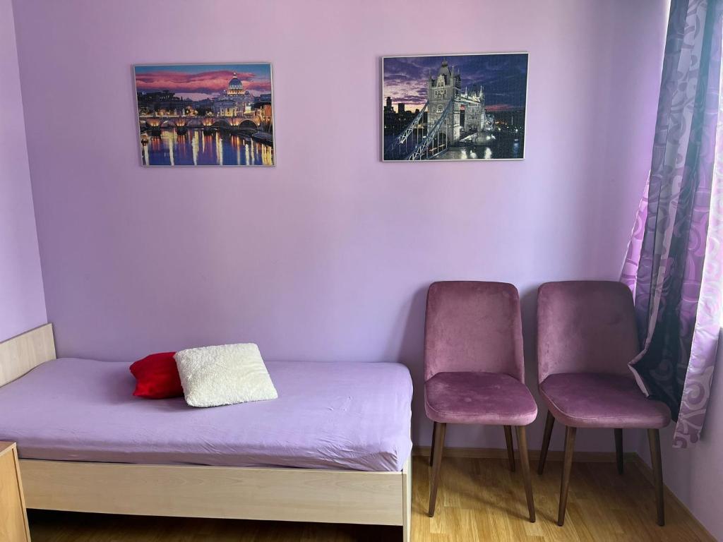 a small room with a bed and two chairs at Apartment Sanik in Varna City