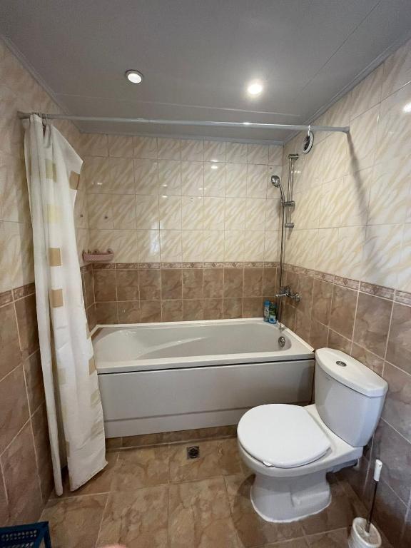 a bathroom with a toilet and a bath tub at Apartment Sanik in Varna City