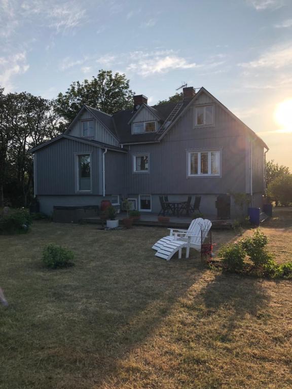 a house with two white benches in the yard at Charmig Ölandsgård in Köpingsvik