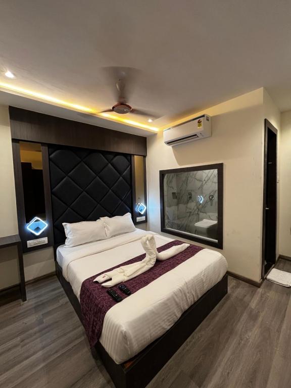 a bedroom with a large bed with a large headboard at Hotel Classio Andheri - Near DN Nagar Metro Station in Mumbai