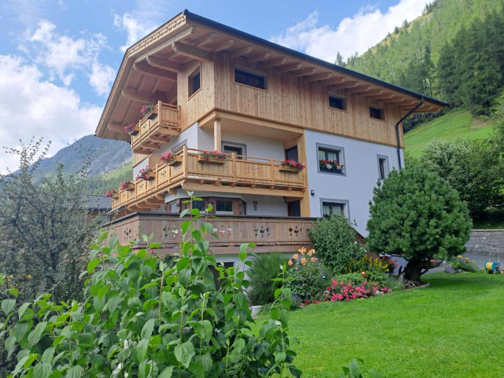 a house with a balcony in the mountains at Ferienwohnung Egger in Prägraten am Großvenediger