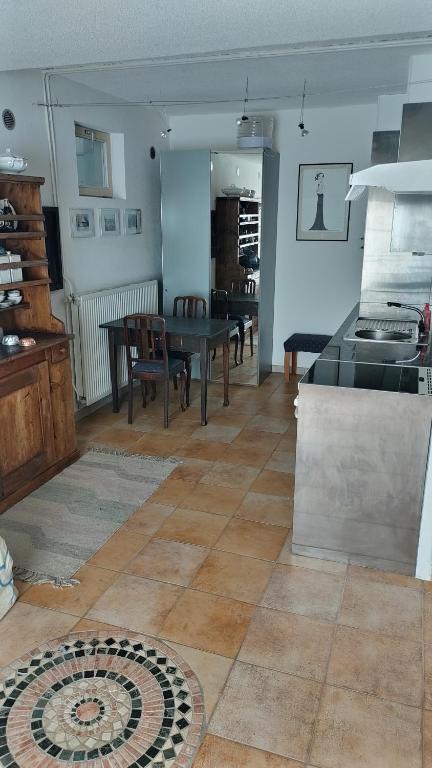 uma cozinha e sala de estar com mesa e cadeiras em Casa Nemea em Neuenegg