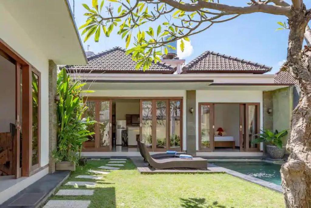 a villa with a pool and a house at Villa Vidya Managed by Manara in Seminyak