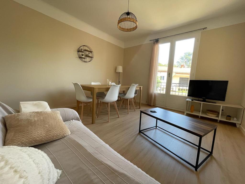 a living room with a couch and a table at LG RITE Appartement avec jardin in Prades