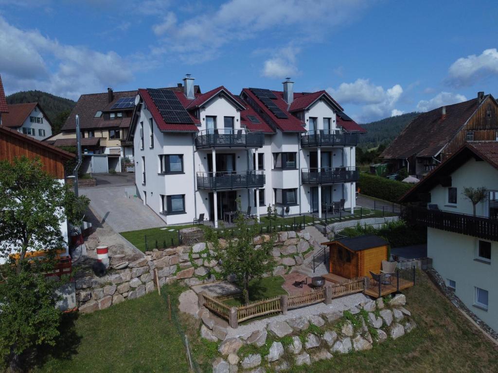 a large white house with a stone wall at Ferienhaus Waldschatz Baiersbronn in Baiersbronn