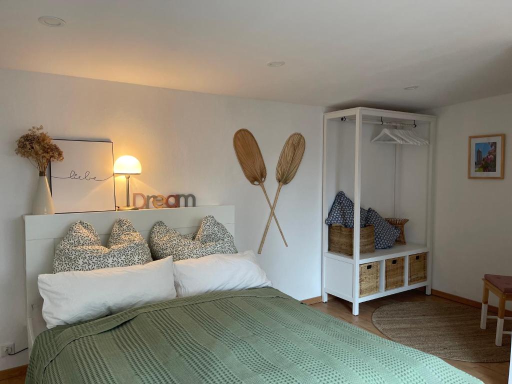 - une chambre avec un lit vert et blanc et un miroir dans l'établissement Kleines gemütliches Bungalow in Havelnähe, à Brandebourg-sur-la-Havel