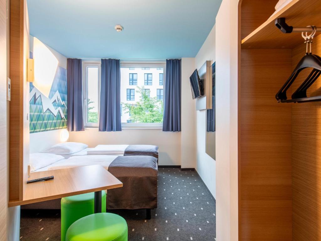 a hotel room with two beds and a table at B&B Hotel Rosenheim in Rosenheim