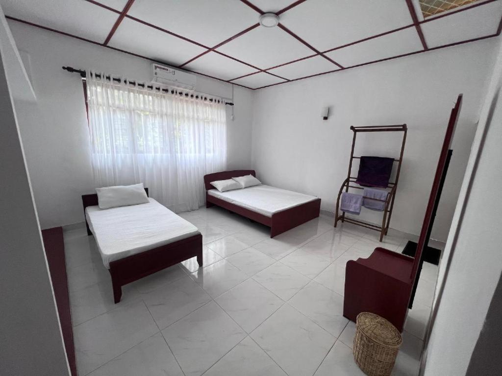 Zimmer mit 2 Betten und einem Stuhl in der Unterkunft The Cinnamon Villa Kandy in Kandy