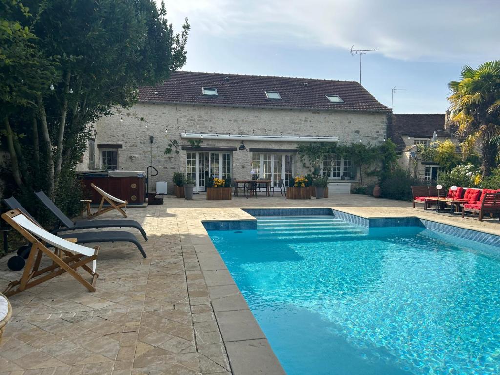 a swimming pool in front of a house at Domaine Chapelle in La Chapelle-la-Reine