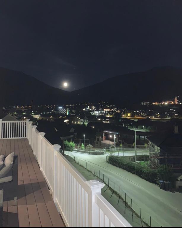 a balcony with a view of a city at night at Two bedroom apartement in Sogndal