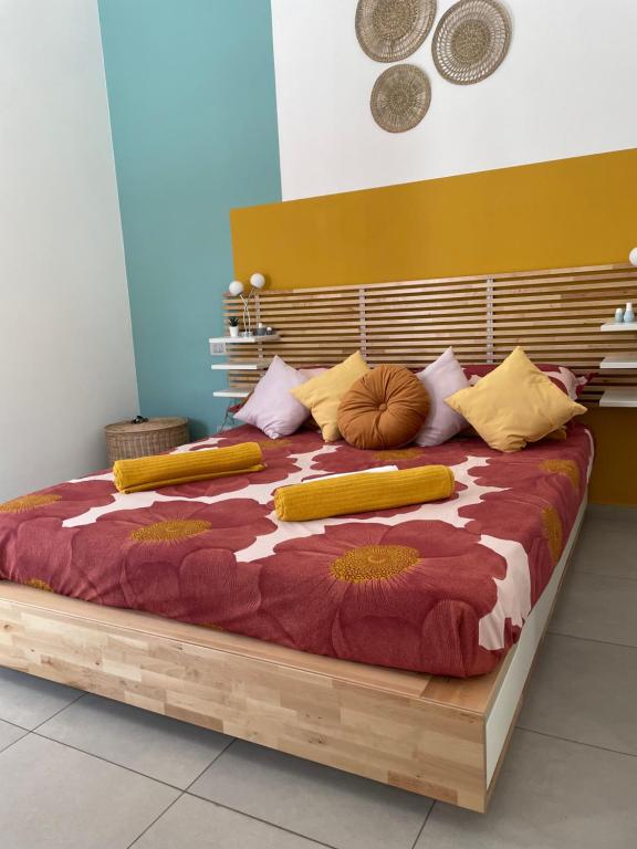 uma grande cama de madeira com almofadas coloridas em Terrazze Alelà apartment em Bari