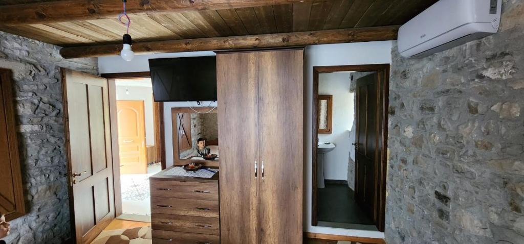 La salle de bains est pourvue d'une armoire en bois et d'un miroir. dans l'établissement Villa Shuaipaj, à Gjirokastër