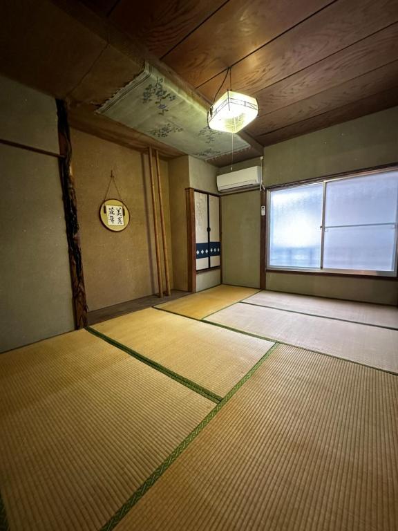 una habitación vacía con un reloj en la pared en 素泊まり民宿とみや, en Oshima