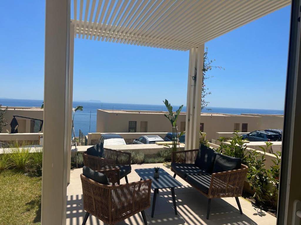 patio z krzesłami i stołem z widokiem na ocean w obiekcie 3M Villa, Green Coast Resort w mieście Palasë