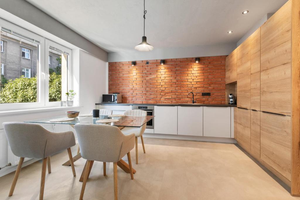 a kitchen with a table and chairs and a brick wall at Sofia Apartment - With parking in Bratislava