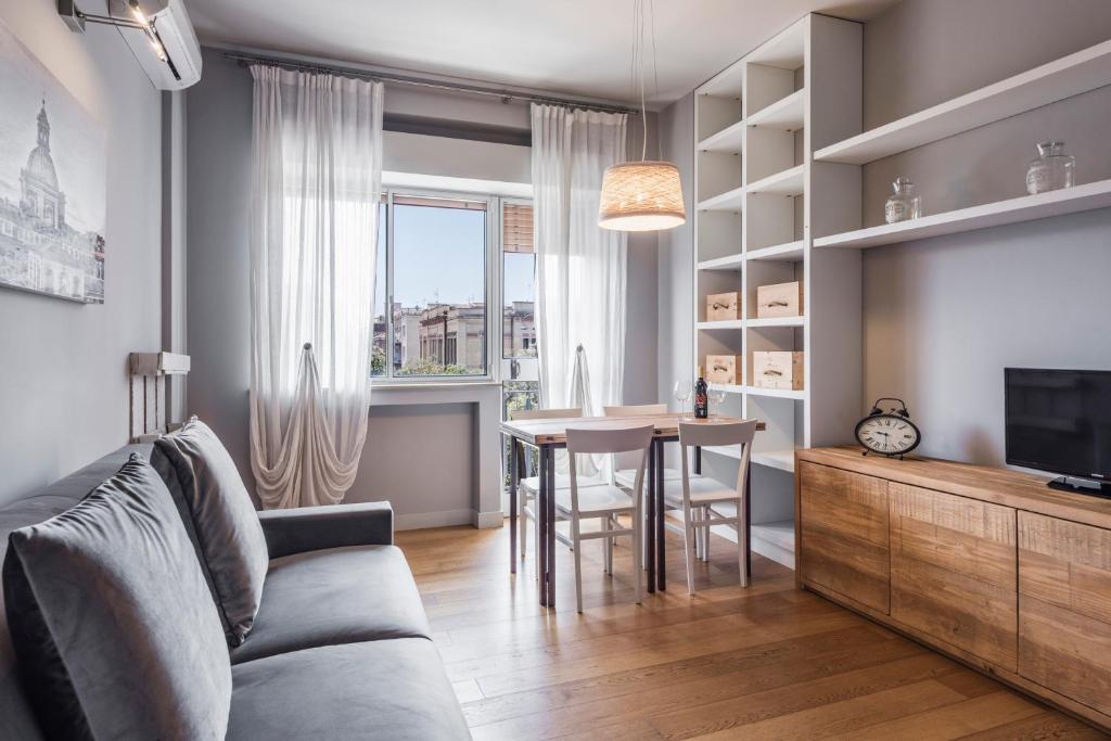 sala de estar con sofá y mesa en Ferrini Home - Suites, en Catania