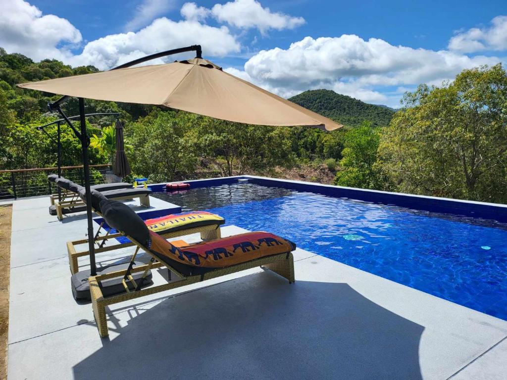 una piscina con sombrilla, silla, mesa y sombrilla en Lost paradise 2 en Hinkong