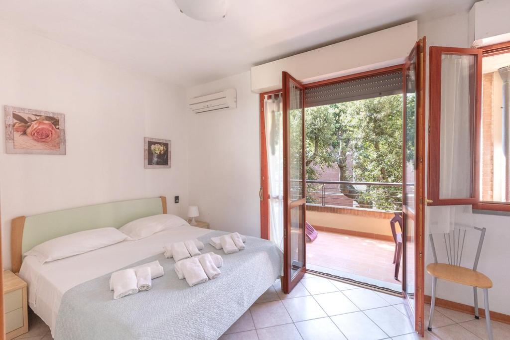 1 dormitorio con 2 camas y balcón en Villa La Cavaliera, en San Vincenzo