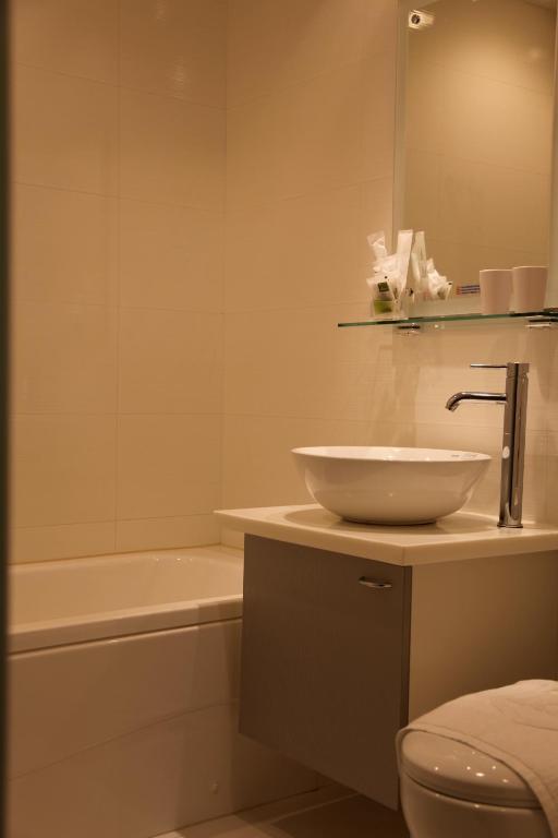 a bathroom with a sink and a toilet and a tub at Royal Hotel in Taipei