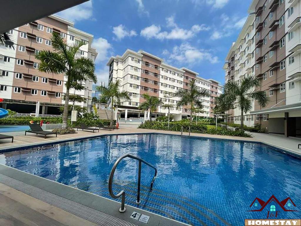 a large swimming pool in front of some apartment buildings at J & F Homestay - Cavite, Philippines in Trece Martires