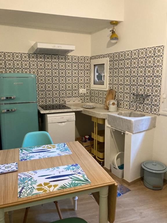 a kitchen with a green refrigerator and a table at La casa di Toni 2 passi dal mare in Finale Ligure