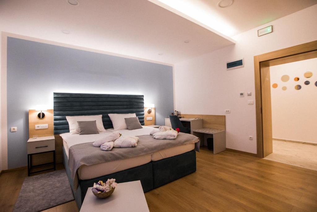 Un dormitorio con una cama grande con dos animales. en Klečka vila B&B rooms, en Ogulin