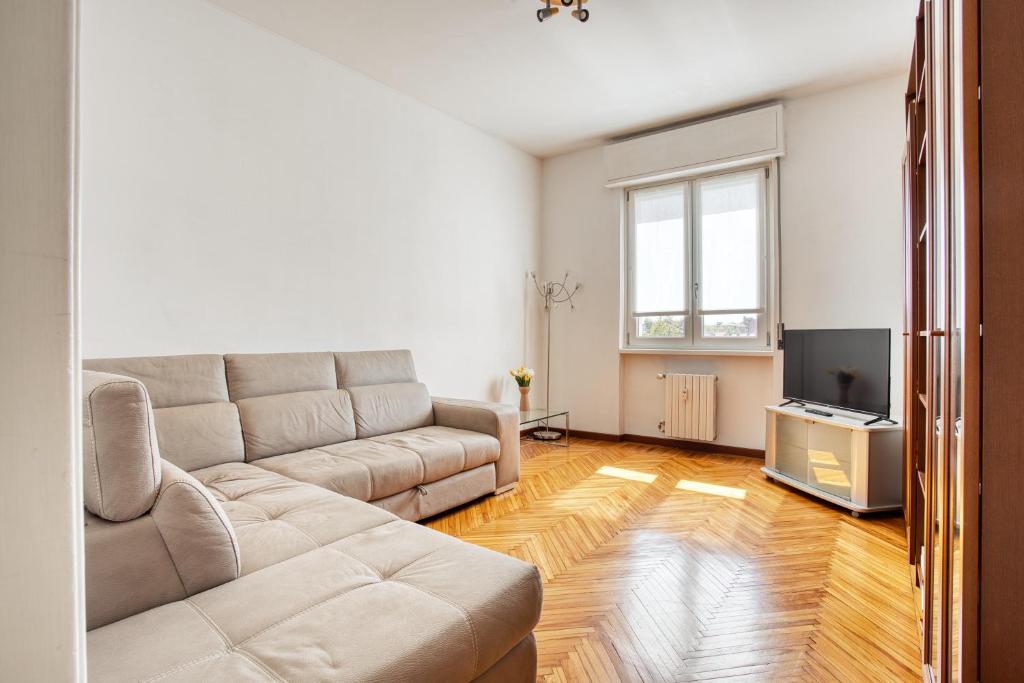 ein Wohnzimmer mit einem Sofa und einem TV in der Unterkunft JOIVY Cosy apt in the Giambellino area in Mailand
