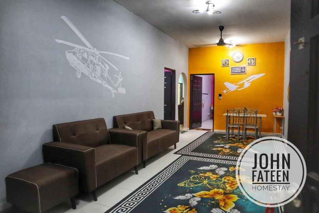 a living room with two chairs and a rug at lumut manjung homestay john faten in Lumut