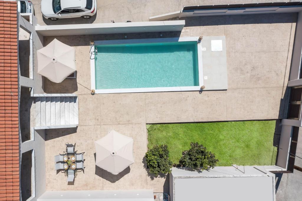 una vista sul tetto di una piscina con ombrelloni di Anastasia Luxury House a Afantou