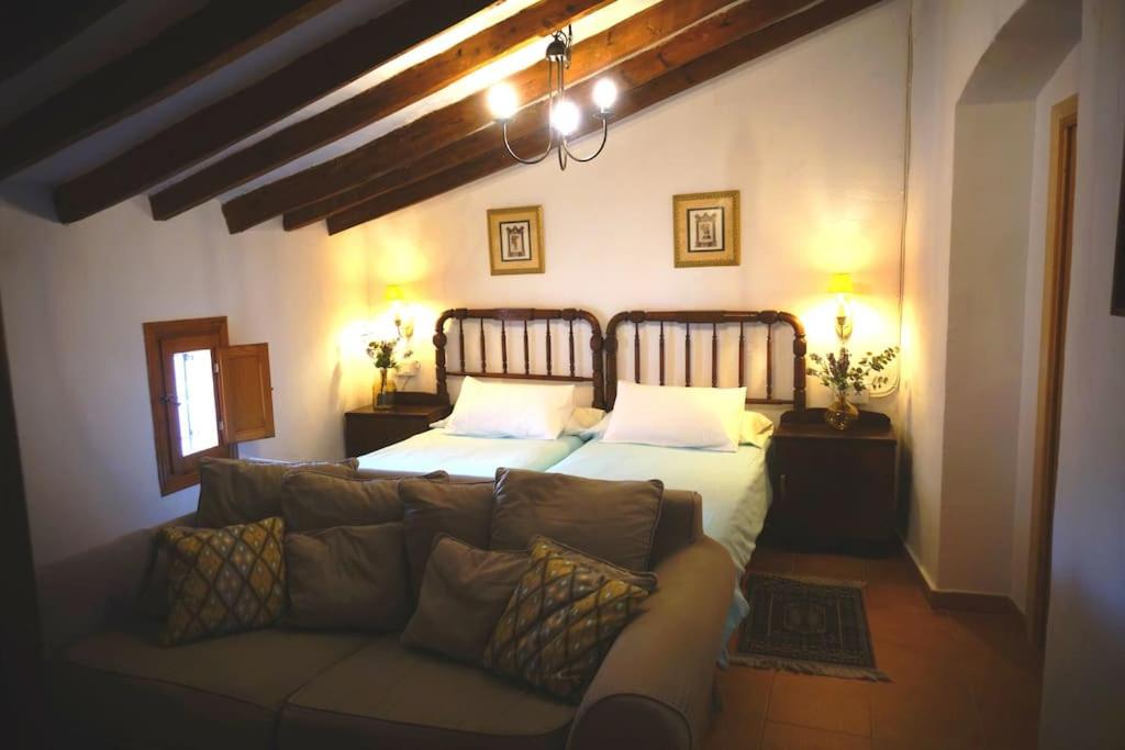 a bedroom with a bed and a couch at CASA CLARA Pueblo, Mar y Montaña in Aigues